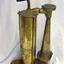 Shiny brass foghorn with wooden handle and stand.