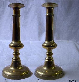 Brass candlesticks with round base and decorative stems.