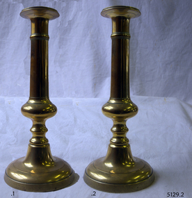 Brass candlesticks with round base and decorative stems.