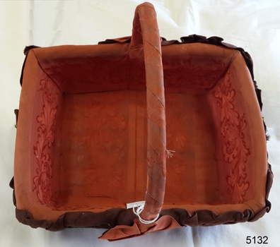 Internal lining of orange-brown fabric has same coloured floral motifs on the ends