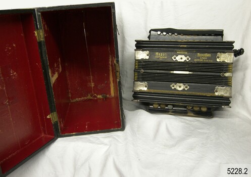 Opened case and closed accordion, view from above. Case has red lining