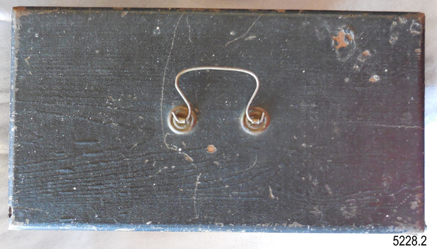 Black painted wooden case has a U-shaped silver metal folding handle on top