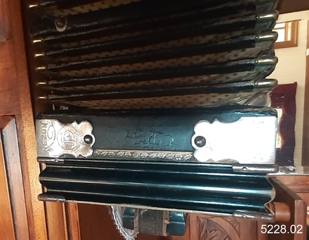 Handwritten identification etched into the accordion's leather surface