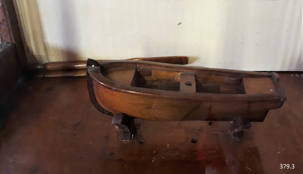 Rowing boat made of wood, oar behind it