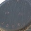 Stamped characters on a round metal plate