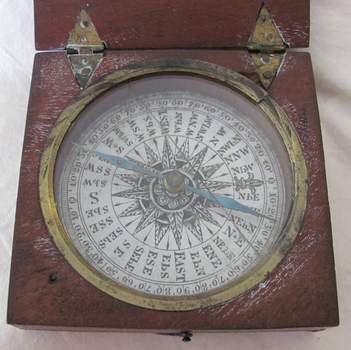 Decorative compass with detailed markings and a blue double-pointed needle