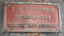 Rectangular iron nameplate with cast text of the maker's name and details