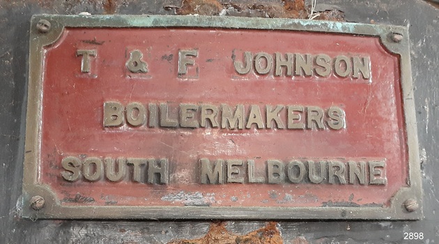 Rectangular iron nameplate with cast text of the maker's name and details