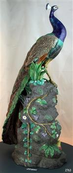Full height of statue with peacock standing on a rock