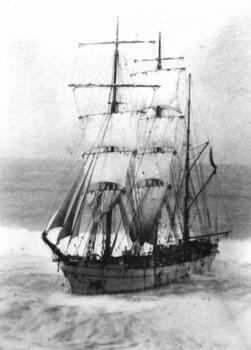 Black and white photograph of a three masted ship at sea