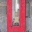 Red, cast metal case with hinged glass front door, displaying barometer's values