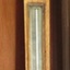 Barometer is in wooden casing, with two glass panels revealing instruments within