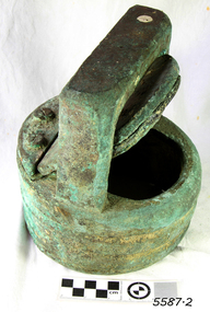 Metal valve is corroded. It is cylindrical and has a metal cover.