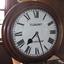 Face of upright clock encased in wood