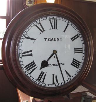 Face of upright clock encased in wood