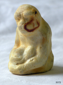 White China monkey's features have been worn down. There is a stain on its face.