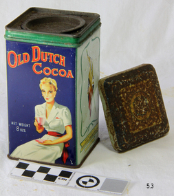 A square upright  tin, previously containing 8 oz of cocoa powder. All four vertical sides are illustrated, with the front having the words 'Old Dutch Cocoa' showing prominently, with a seated lady drinking cocoa. There are external and internal lids, and these together with the top of the base are very rusty, but the printed illustrations are quite legible.