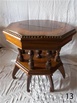 Turned pillars support the table top, which has inlaid pieces of different timbers.  one pillar per leg and one pillar in the centre.