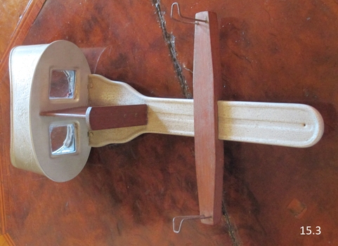 The wood and metal slide holder has a channel on the metal holder along which it can move