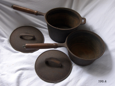 Heavy metal pots with matching lids. Pots have wooden handles