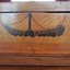 Inlaid image of a paddle steamer boat with a tall funnel and paddle wheel.