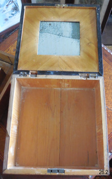 The lid is lined with pieces of light coloured wood.