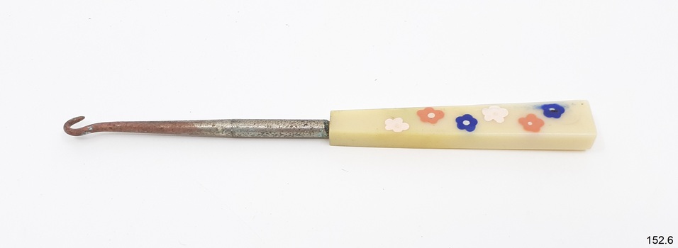 Metal shank and white rectangular handle with coloured floral motifs