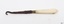 Button hook is joined to brass collar attached to a white, handle that has a rounded end