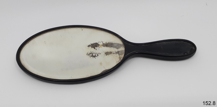 Oval mirror with black surround and handle