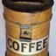 Top of canister has its handle raised. Body has raised rings around it. A label is attached.