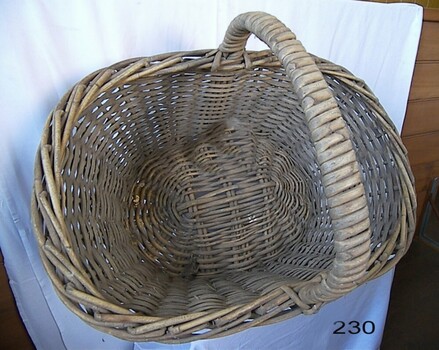 Oval cane basket with strong central handle