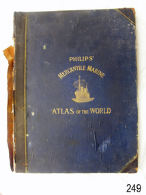 Large book, blue cover, black spine and corners, embossed gold letters, image of gold ship on water