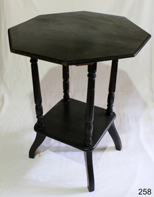 Dark wood octagonal table with square shelf near base, set between the four rounded legs