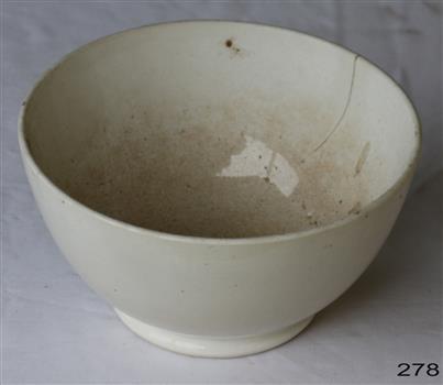 White ceramic earthenware bowl with narrow rim. Bad crack and stains.