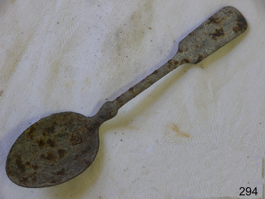 A metal teaspoon. Badly corroded.