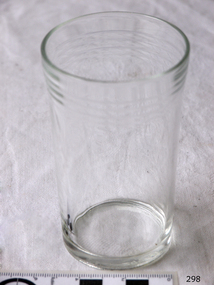 Cylindrical clear drinking glass with ridges around lip.