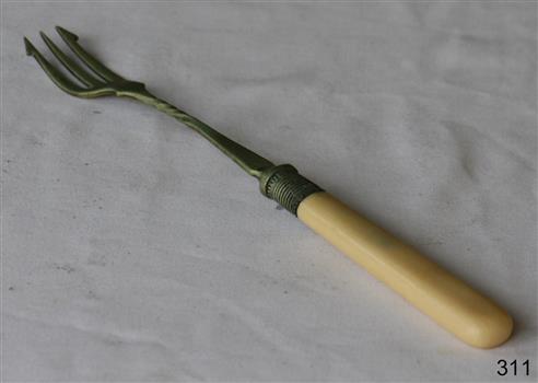 A long metal fork with a bone handle. The fork has three prongs.