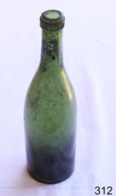 A green glass bottle with the residue of the contents still inside.