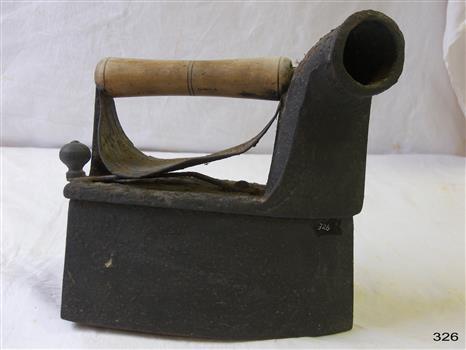 The iron has a wooden handle with a heat guard. It has a chimney or funnel.