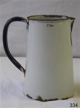 White metal enamel jug, with dark metal rim and dark blue handle, tapering inward towards top.