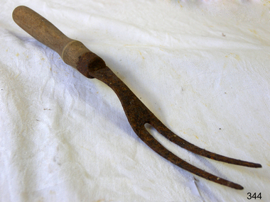 A two pronged metal carving fork with a wooden handle.