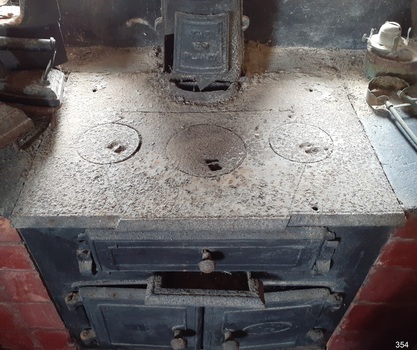 Three round removable cook plates on top of the stove, with the flue at the back