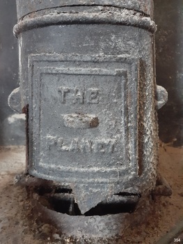 Removable plate on front of flue with the maker's name within a rectangular border "THE PLANET"