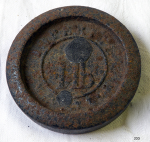 Round metal weight with inscription 