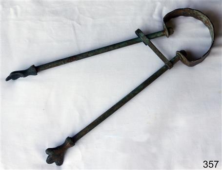 Brass fire tongs with claw shaped ends and a holding clip to keep the two parts together..