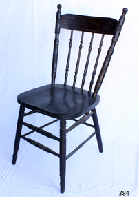 Wooden dark varnished dining chair with four vertical stretchers, and two rungs running the whole way around the legs, although at different heights.