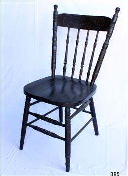  Wooden dark varnished dining chair with four vertical stretchers, and two rungs running the whole way around the legs, although at different heights.