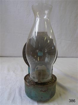 Lamp with blue metal tank and base for the rear reflector, and a narrow bulbous glass lamp cover