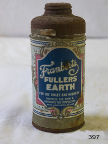 A round metal container with a perforated lid, with a coloured label indicating that it  originally contained Fuller's Earth.