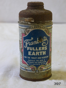 A round metal container with a perforated lid, with a coloured label indicating that it  originally contained Fuller's Earth.